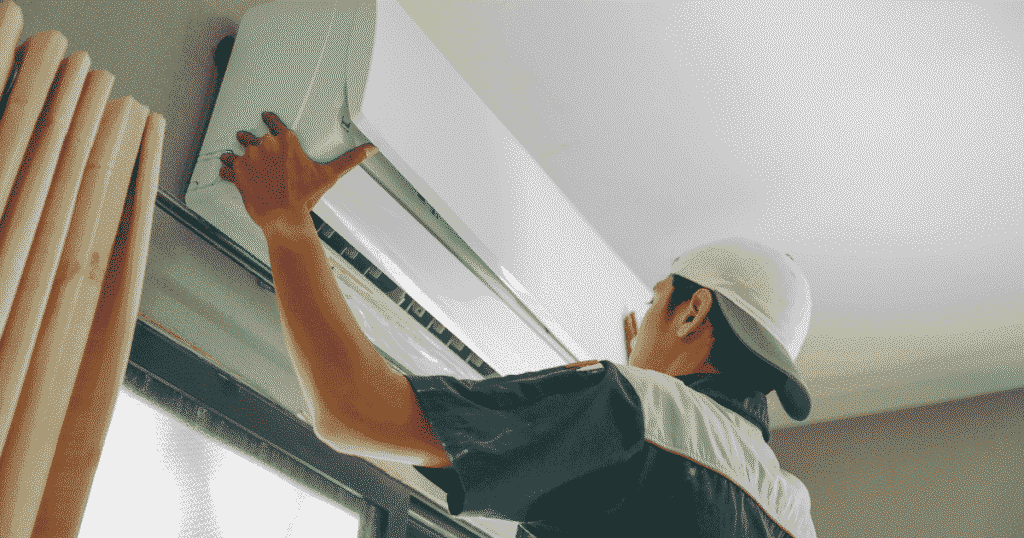 作業員が室内エアコンを取り付けしている様子