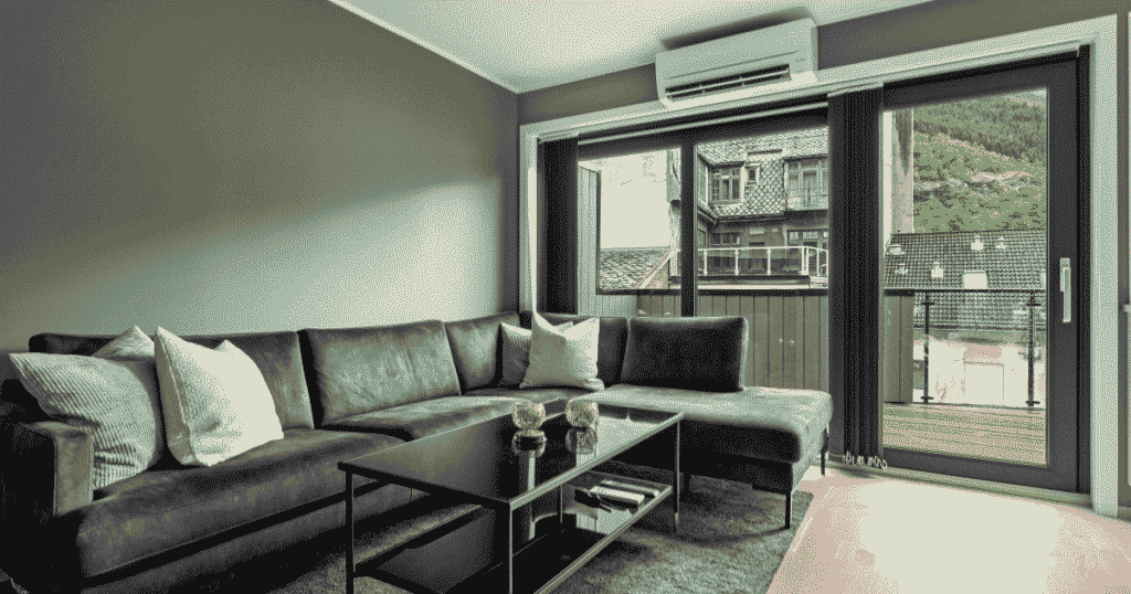 グレーのリビングに設置されたエアコンとソファ