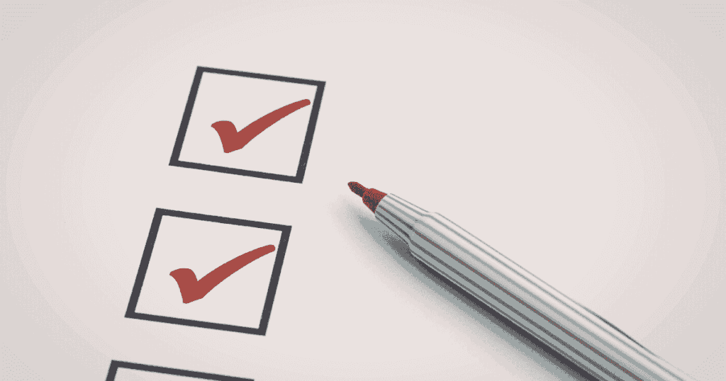 赤いチェックマークが入ったチェックリストとペン先のアップ