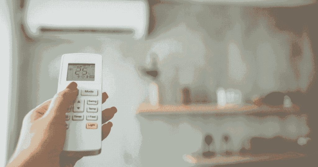 リモコンでエアコンの温度を操作している手元の様子