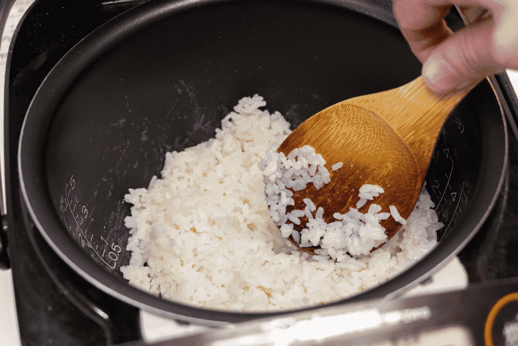 炊き上がったご飯をしゃもじでほぐしている様子