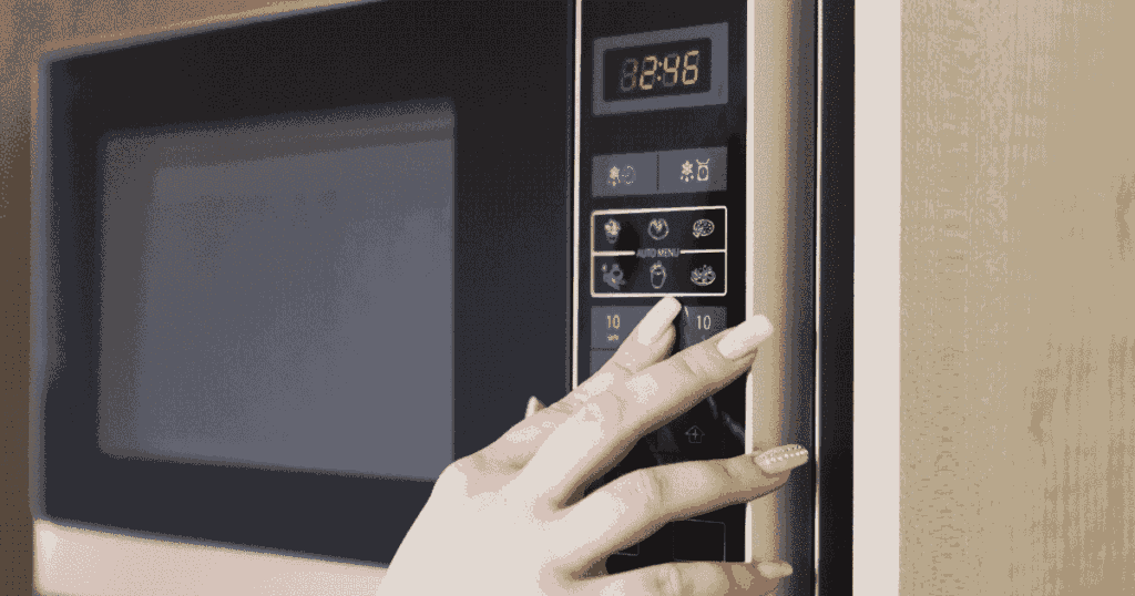 オーブンレンジの操作ボタンを押す手元