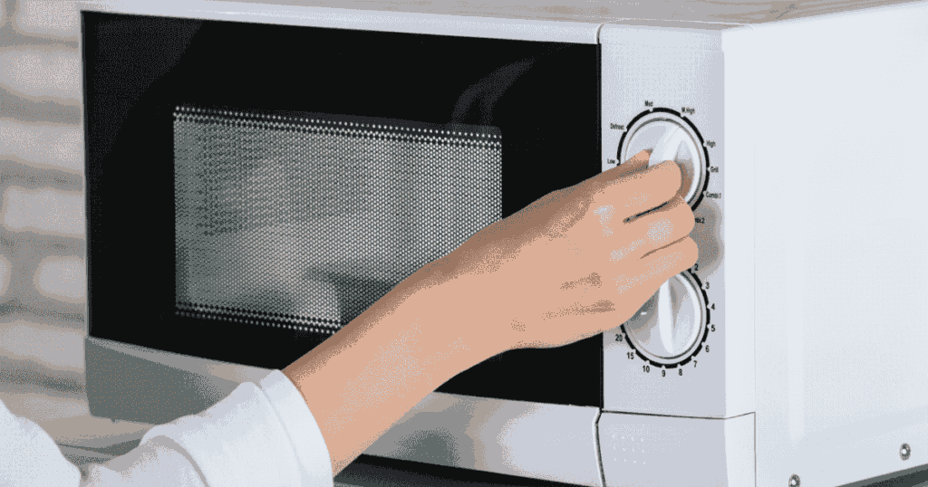 オーブンレンジのダイヤルを回す手元