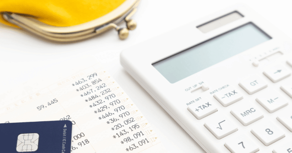 電卓と家計簿から電気代を計算しているイメージ