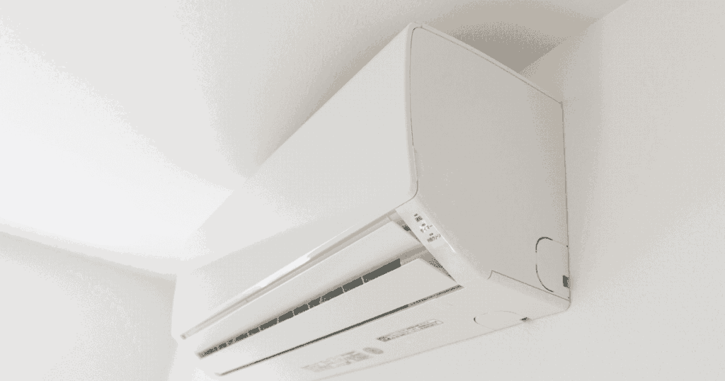 部屋の壁に設置されたエアコンを下から見上げた構図