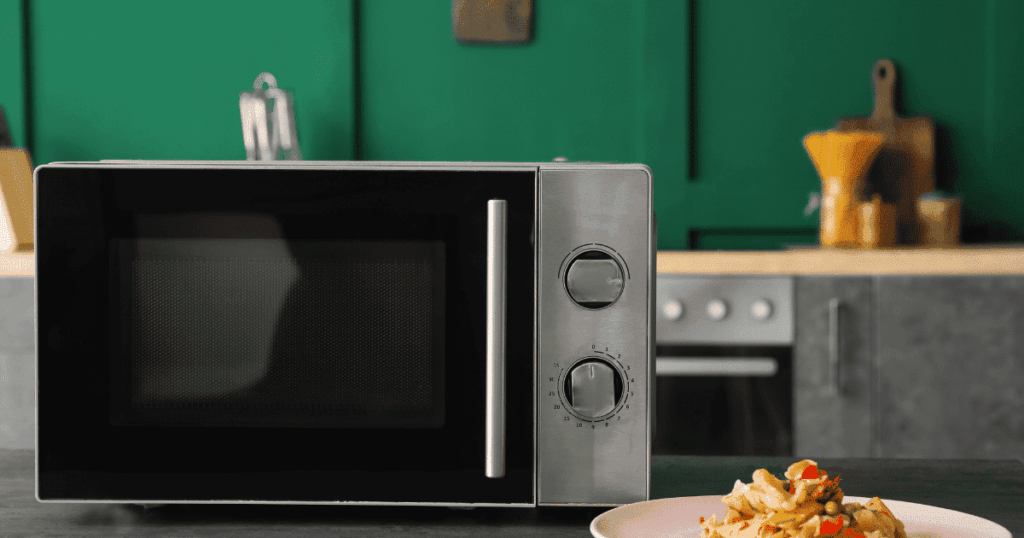 黒色の電子レンジと料理皿が置かれたキッチンの様子