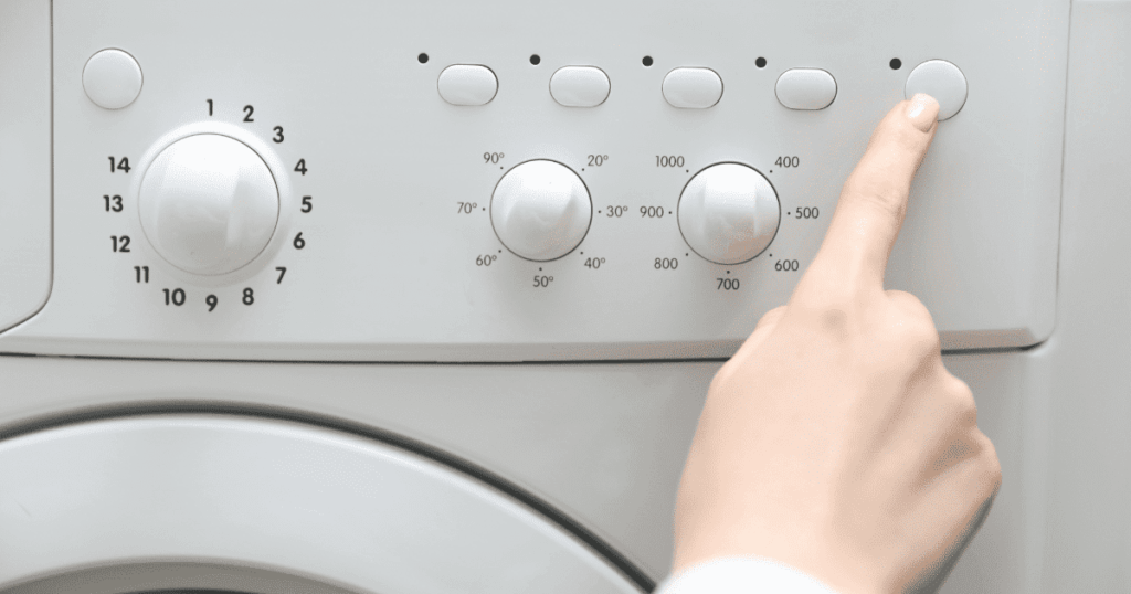 洗濯機の操作パネルを指で押して運転を開始する様子