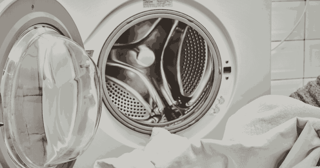 ドラム式洗濯機の扉を開けて洗濯物を出し入れする様子