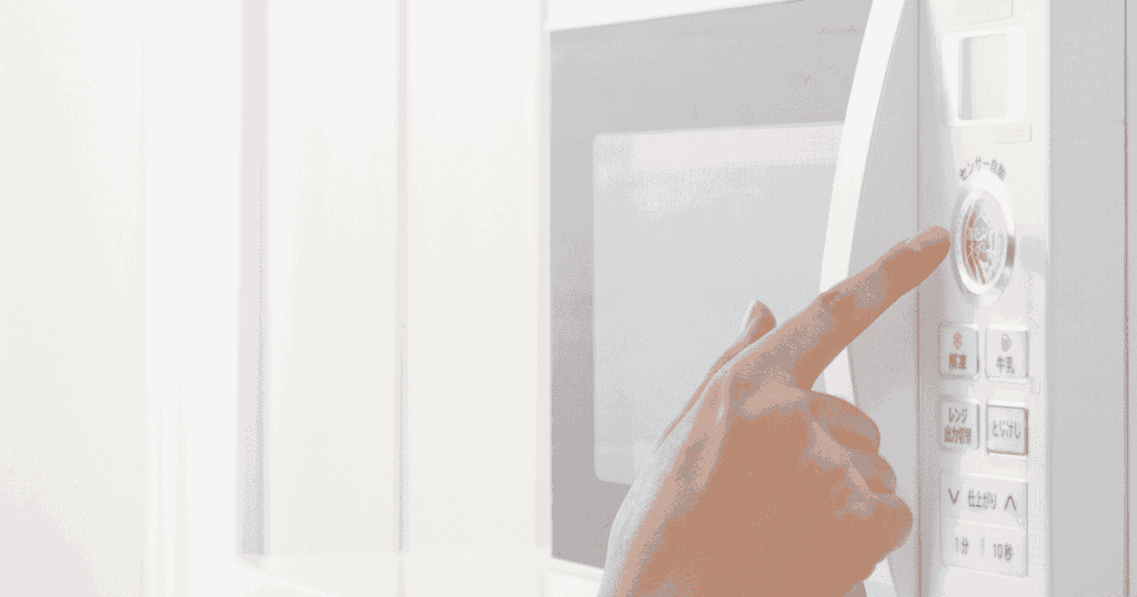 電子レンジの操作パネルを指で押す手元