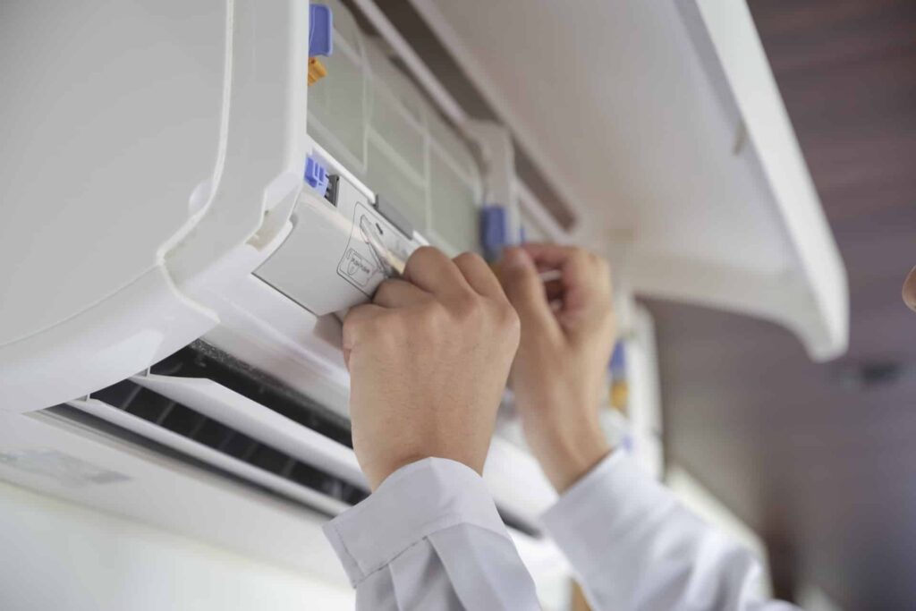 エアコンの修理をする男性の手