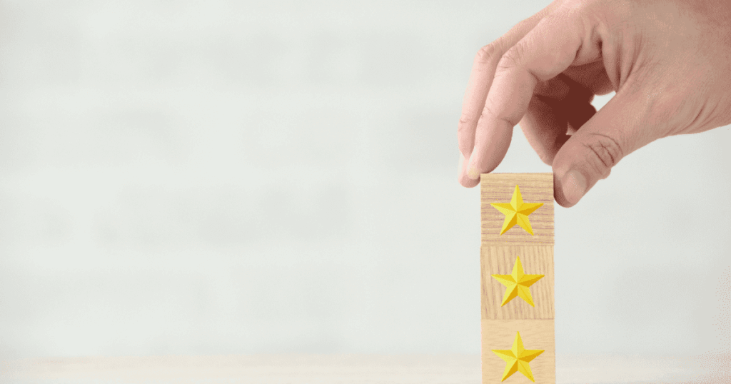 星マーク付きの木製ブロックを手で積み上げる評価イメージ