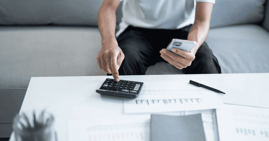 電卓とスマートフォンで暖房費を計算しているイメージ