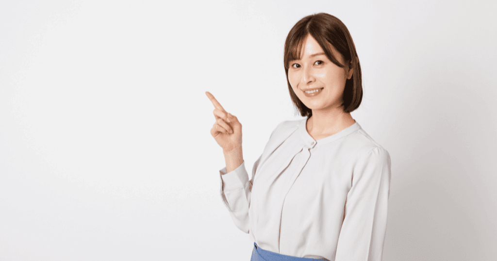 笑顔で斜め上を指さす女性
