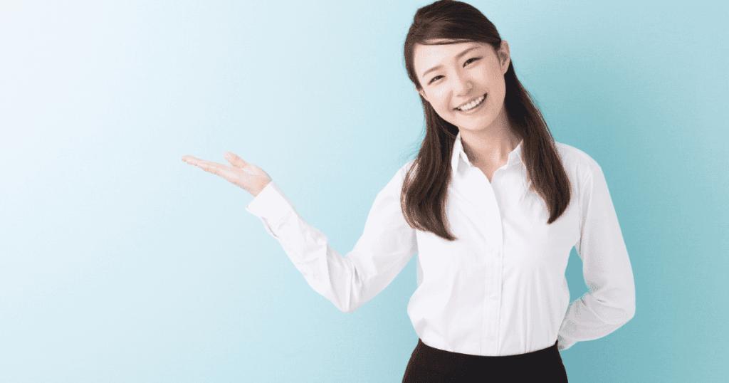 手のひらを上に向けて案内する笑顔の女性