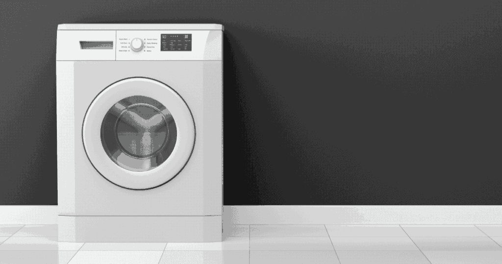 グレーの壁の前に置かれた白いドラム式洗濯機