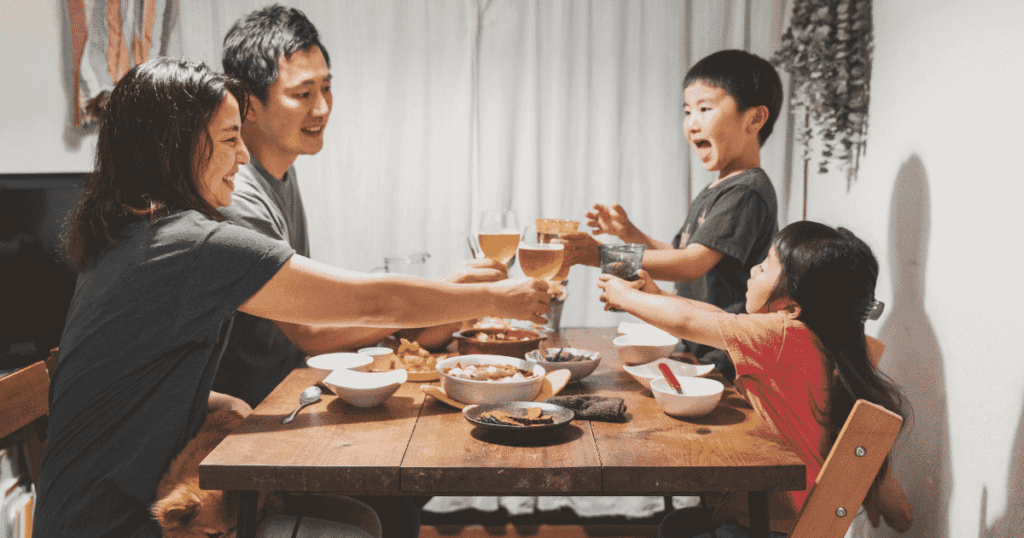食卓を囲んで乾杯する家族