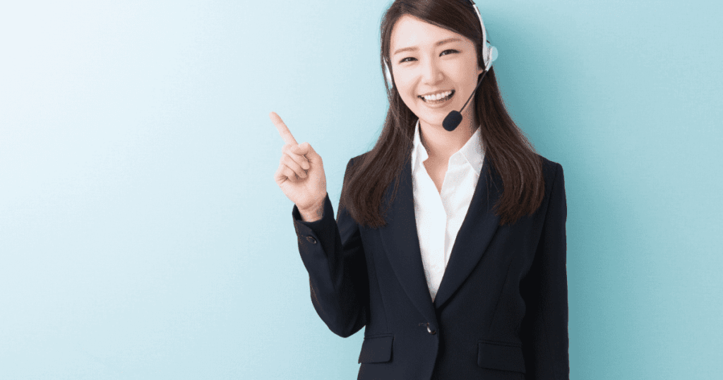 ヘッドセットを着けて指を差す女性